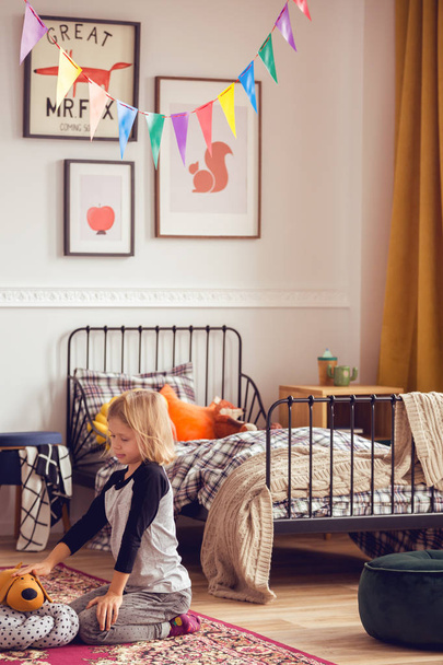 Blonde kid playing with toys in vintage styled unisex bedroom - Foto, immagini