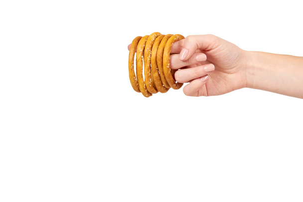 Hand with dried bagel, fresh baked bun, fast food snack. - Φωτογραφία, εικόνα