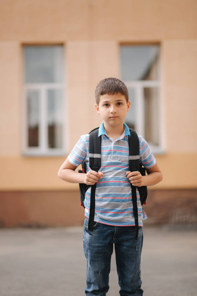 Симпатичний маленький хлопчик з рюкзаком повертається додому після уроків шолля
 - Фото, зображення