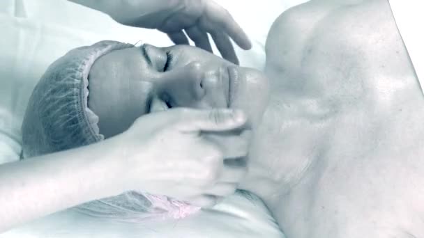Красива доросла жінка робить масаж обличчя в салоні краси
. - Кадри, відео
