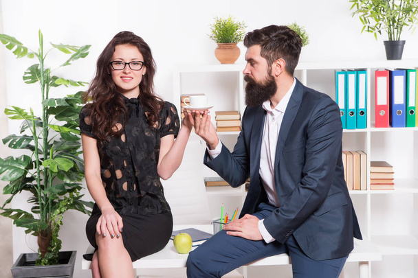 Man and woman conversation coffee time. Office rumors. Office coffee. Couple coworkers relax coffee break. Share coffee with with colleague. Flirting colleagues. Bearded man and attractive woman - 写真・画像