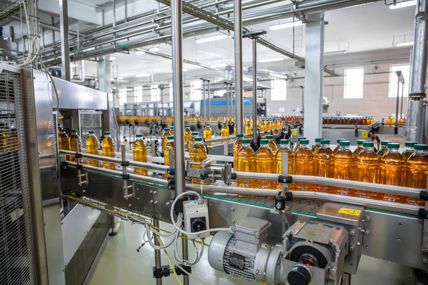 Förderband oder Linie in Getränkeindustrie mit moderner automatisierter industrieller Maschinenausrüstung. Plastikflaschen mit frischem Bio-Saft im Fabrikinneren - Foto, Bild