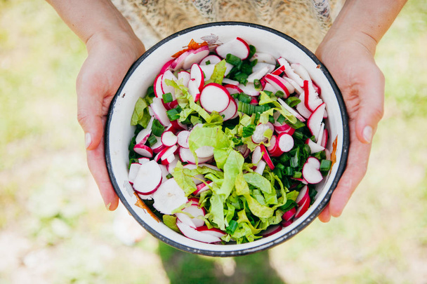 Frau hält Schale mit frischem Salat in der Hand - Foto, Bild