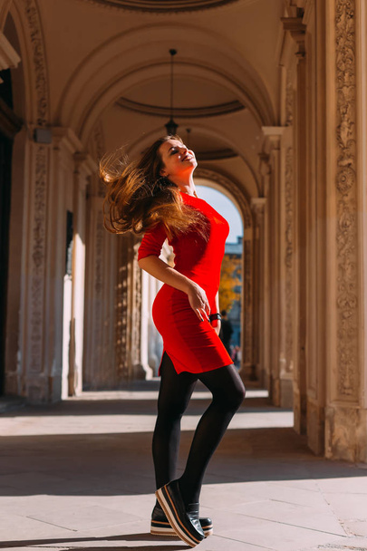 girl in a red dress waving her hair and posing. stylish clothes. - Foto, Imagen