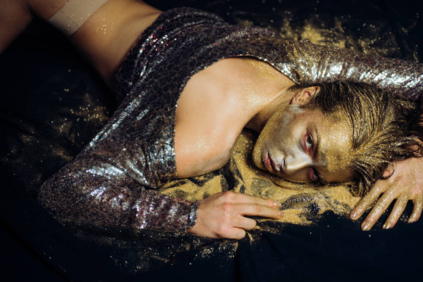 Golden skin. Sexy girl face makeup body art metallized color. Spa wellness. Richness and wellbeing. Golden mask. Luxury beauty procedure. Golden lady relaxing. Pure gold. Vogue and glamour concept - 写真・画像