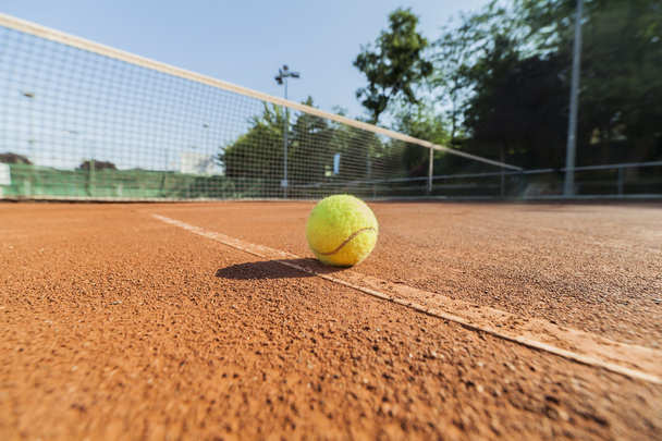 Tennispallo savikentällä
 - Valokuva, kuva