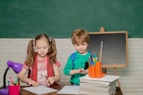 Back to school and happy time. Friendly child in classroom near blackboard desk. Kids gets ready for school. Teachers day. - Фото, изображение