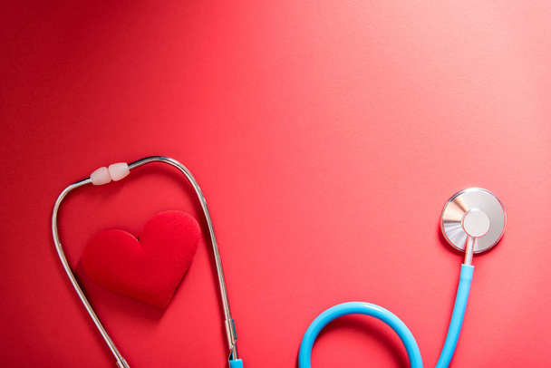 red heart and stethoscope on red background - Foto, afbeelding