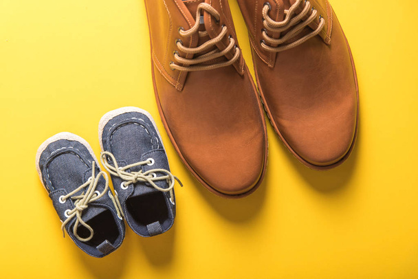 father and son shoes on yellow background , father day concept - Foto, imagen