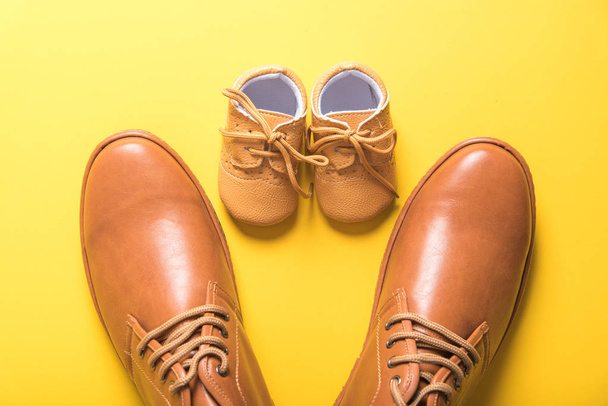 father and son shoes on yellow background , father day concept - Photo, image