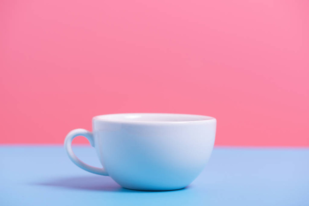 white coffee cup on blue and pink paper , minimal style backgrou - Фото, зображення