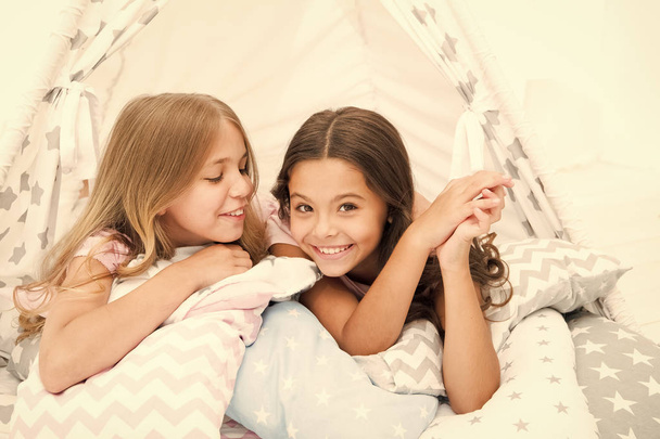 Sisters share gossips having fun at home. Pajamas party for kids. Cozy place tipi house. Sisters or best friends spend time together lay in tipi house. Girls having fun tipi house. Girlish leisure - Foto, imagen