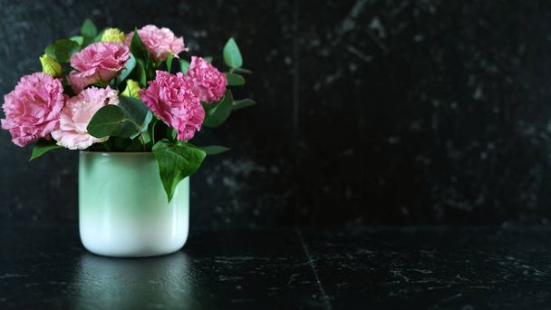 Balcão de mármore preto com vaso de flores lisianthus rosa com espaço de cópia
. - Foto, Imagem