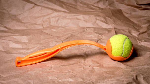 オレンジ色のハンドルを持つテニスボールランチャー - 写真・画像