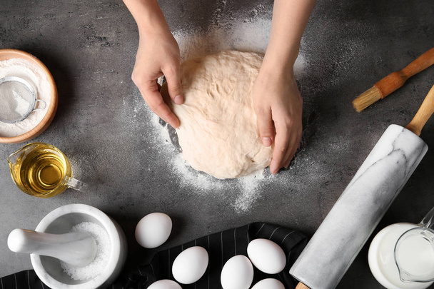 Panadero femenino preparando masa de pan en la mesa de la cocina, vista superior
 - Foto, Imagen