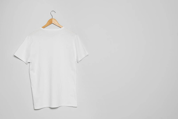Hanger with blank t-shirt on gray background. Mock up for design - Foto, Imagem