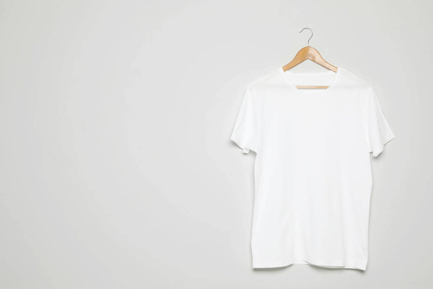 Hanger with blank t-shirt on white background. Mock up for design - Fotó, kép