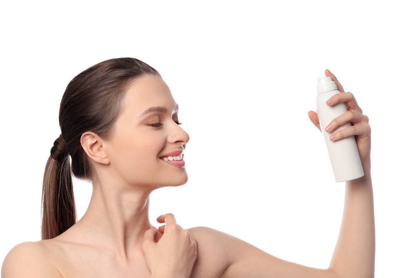 Young woman applying thermal water on face against white background. Cosmetic product - Valokuva, kuva