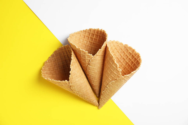 Waffle empty ice cream cones on color background, flat lay - 写真・画像