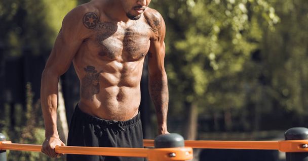 Bracci di allenamento uomo in forma su barre parallele, Training Triceps
 - Foto, immagini