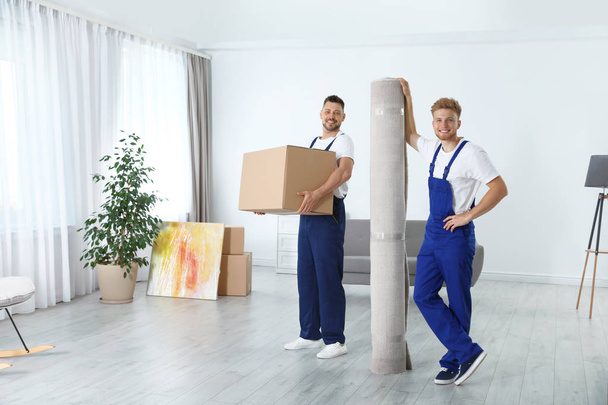 Moving service employees with box and carpet in room - Foto, Imagem