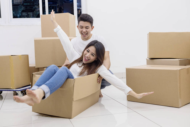 Young Asian couple riding in a cardboard box - Foto, Imagen