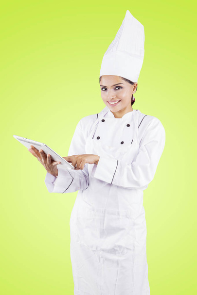 Young female chef using a tablet in the studio - Foto, Imagem