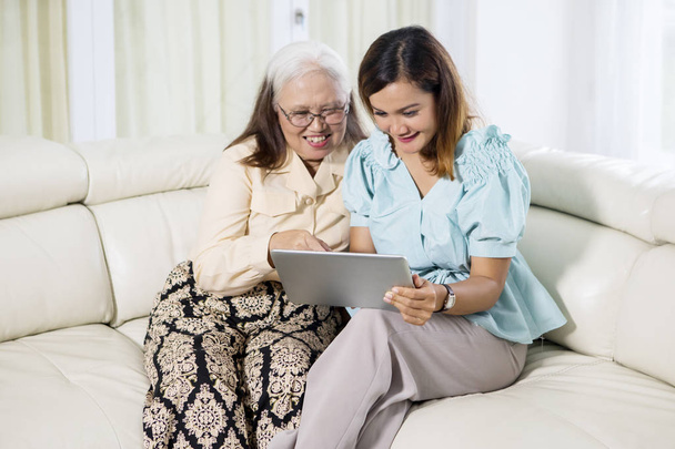 Young woman using a tablet with her mother - Photo, Image