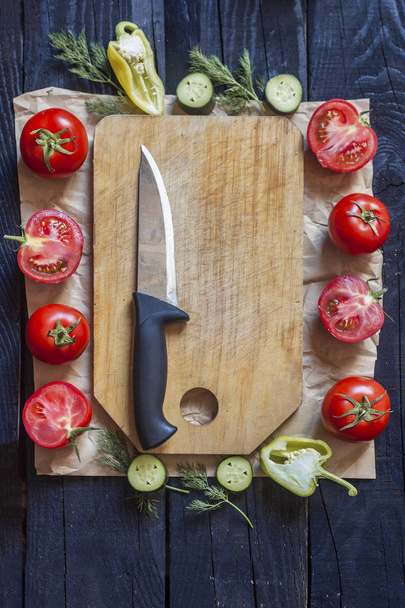 Salad ingredients. Fresh raw vegetables on wood. Healthy cooking salad. Cutting board with a kitchen knife. - Foto, imagen