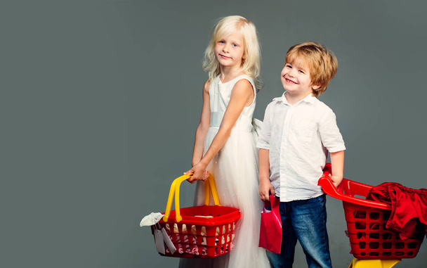 Kids store. Mall shopping. Buy products. Play shop game. Cute buyer customer client hold shopping cart. Buy with discount. Girl and boy children shopping. Couple kids hold plastic shopping basket toy - Foto, Bild