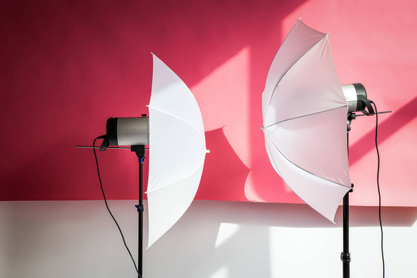 Valokuvaus studio flash strobe valon ja kuvan ottamisen vaaleanpunainen väri. Työkalut ammattivalokuvaajille työskentelevät studiossa
. - Valokuva, kuva