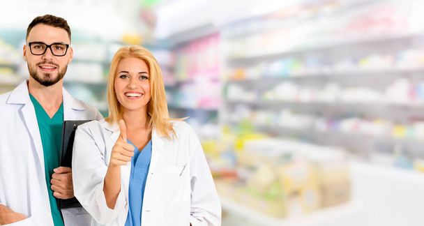 Pharmacist working with colleague in pharmacy. - 写真・画像