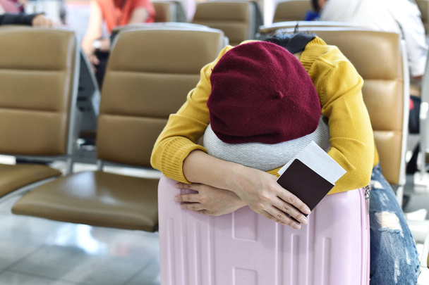Viajero durmiendo en la sala de espera terminal del aeropuerto, Pasajero cansado de vuelo de embarque retrasado, Viajes y concepto de transporte
. - Foto, imagen