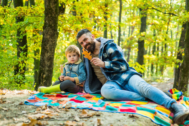 落ち葉。かわいい息子とヒップスターひげのお父さんは森の中で一緒に時間を過ごします。家族の時間だ家族の余暇残忍なあごひげの男と小さな男の子は秋の自然を楽しみます。家族の価値観。ワンダーラストコンセプト - 写真・画像