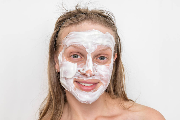 Mujer con máscara de crema blanca natural en la cara
 - Foto, imagen