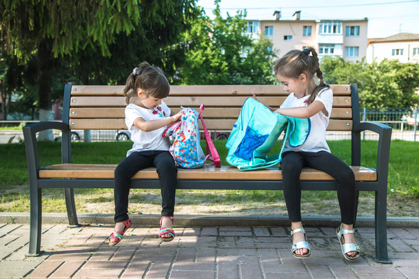 Back to school. Happy cute industrious kids sitting on the bench - Fotografie, Obrázek