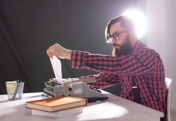 gente, escritor y concepto hipster - joven escritor elegante que trabaja en la máquina de escribir
 - Foto, imagen