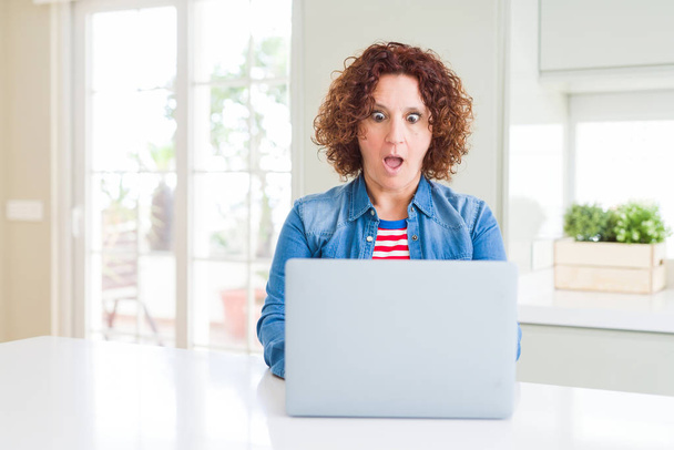 Старша жінка, яка працює за допомогою комп'ютерного ноутбука, боїться шокувати з несподіваним обличчям, боїться і схвильована виразом страху
 - Фото, зображення