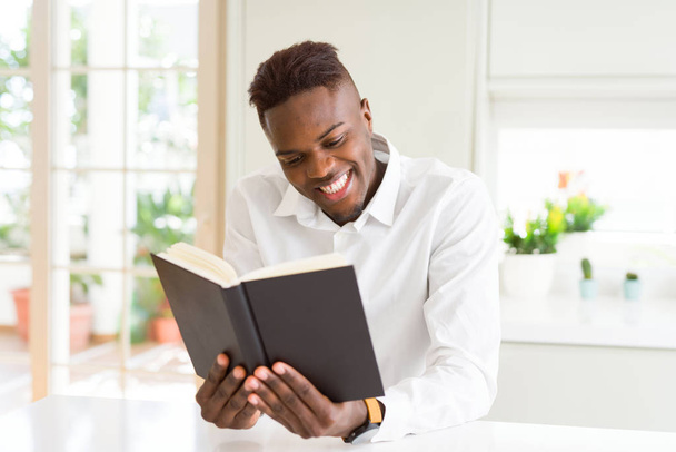 Young african man reading a book, studying for univeristy smilin - Fotografie, Obrázek