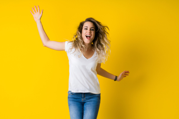 schöne junge blonde Frau springt glücklich und aufgeregt über isol - Foto, Bild