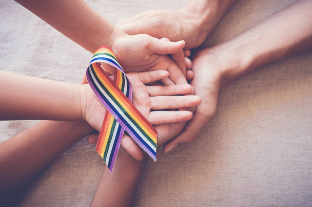 Dumy gejowskiej rainbow wstążki dla Lgbt świadomości trzymając się za ręce - Zdjęcie, obraz