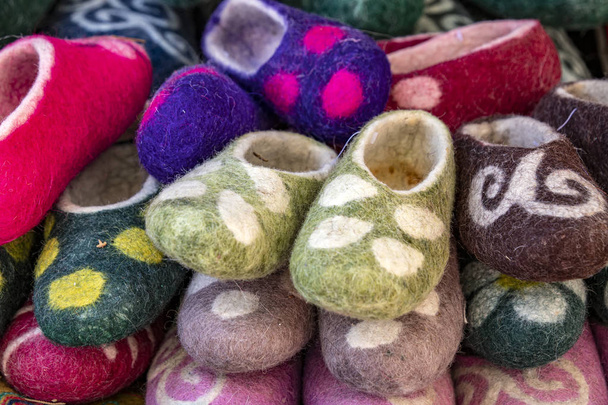 Zapatillas orientales hechas a mano hechas de fieltro con un adorno nacional. Mercado. Viajar. Kirguistán
 - Foto, imagen