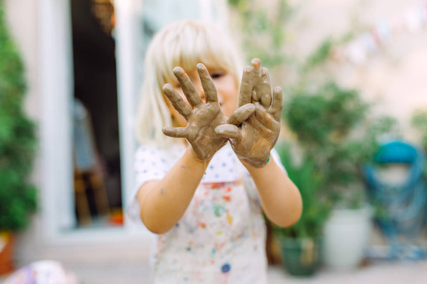 泥だらけの手を見せる小さな女の子 - 写真・画像
