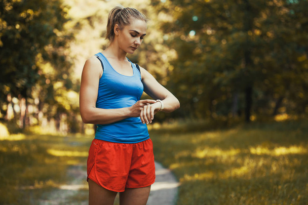Όμορφη γυναίκα αθλητής κάνει ασκήσεις πριν από το τρέξιμο στο δάσος - Φωτογραφία, εικόνα