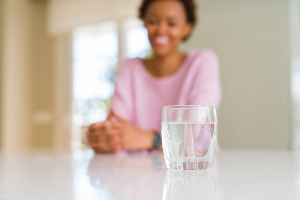 Linda jovem afro-americana bebendo um copo de água doce
 - Foto, Imagem