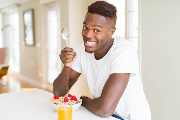 Csinos afro-amerikai férfi étkezés heatlhy gabonafélék és bogyók - Fotó, kép