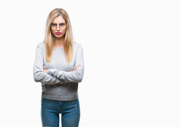Young beautiful blonde woman wearing glasses over isolated background skeptic and nervous, disapproving expression on face with crossed arms. Negative person. - Fotografie, Obrázek