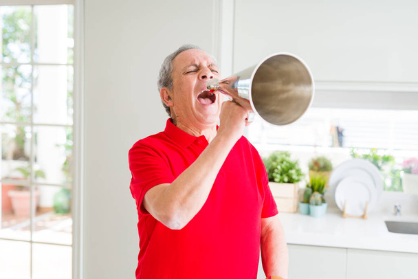 Senior man shouthing excited through vintage metal megaphone - Fotoğraf, Görsel