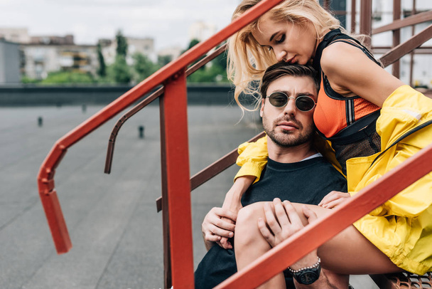 blonde woman and handsome man in glasses sitting on stairs  - Valokuva, kuva