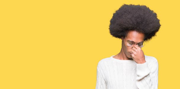 Jeune homme afro-américain aux cheveux afro portant des lunettes fatigué se frottant le nez et les yeux ressentant fatigue et maux de tête. Concept de stress et de frustration
. - Photo, image